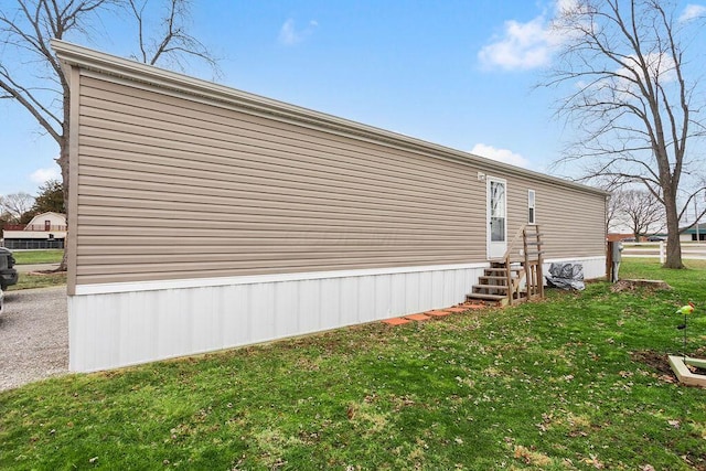 view of side of home featuring entry steps and a lawn