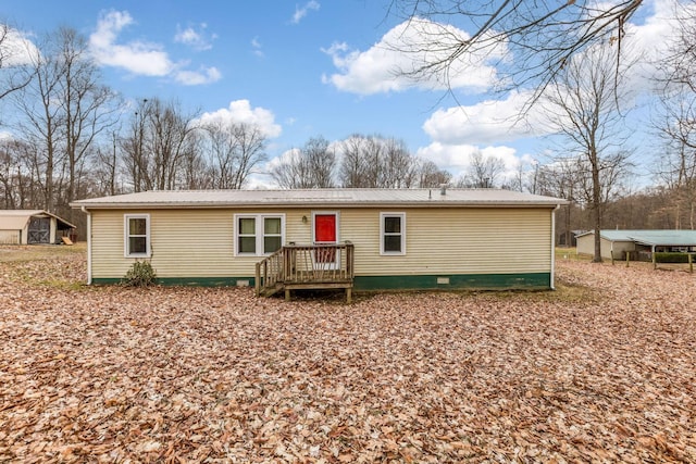 rear view of property featuring metal roof, crawl space, and an outdoor structure