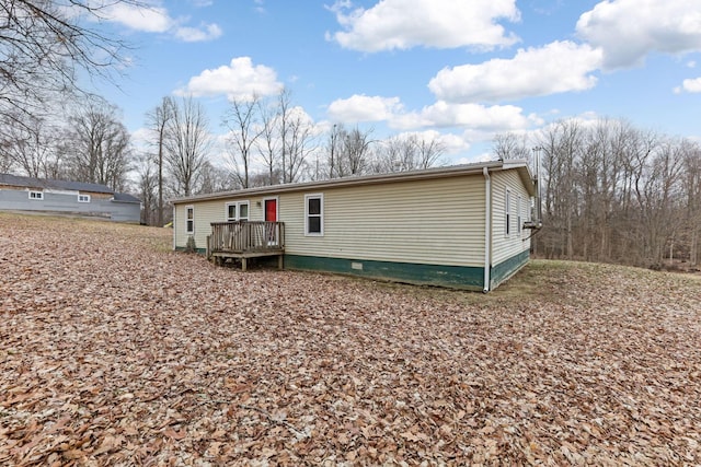 back of property featuring a deck and crawl space