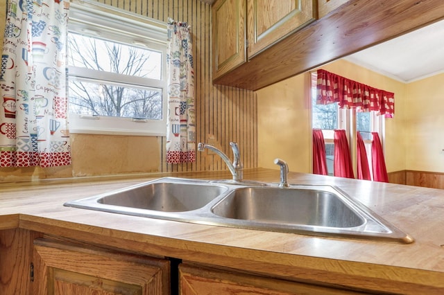 kitchen featuring brown cabinetry, light countertops, and a sink