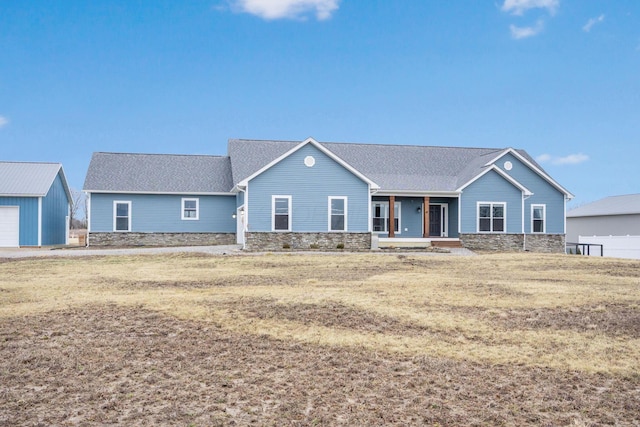 single story home with covered porch, a front yard, and roof with shingles