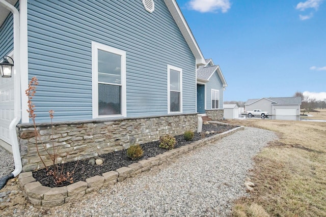 view of side of property with stone siding and a garage