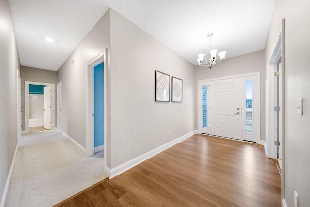 entryway with a notable chandelier, wood finished floors, and baseboards