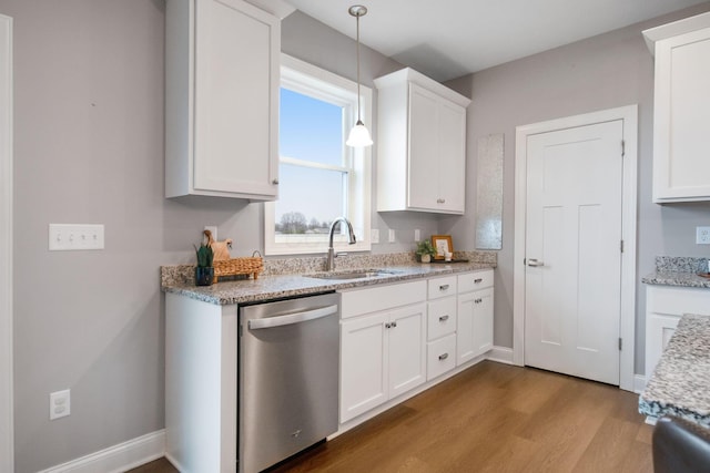 kitchen featuring a sink, stainless steel dishwasher, wood finished floors, and white cabinetry