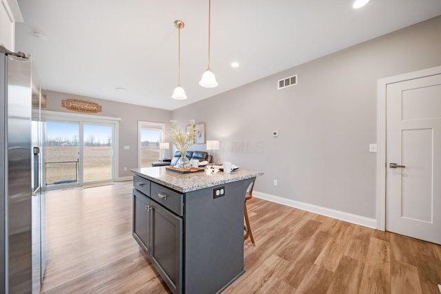 kitchen featuring visible vents, stainless steel fridge, baseboards, and light wood finished floors