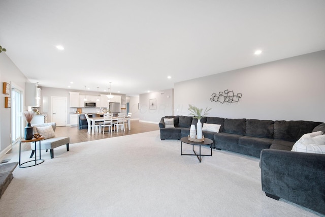 living area with light wood-style flooring, recessed lighting, and baseboards
