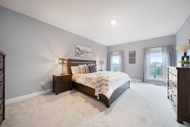bedroom with baseboards and light carpet