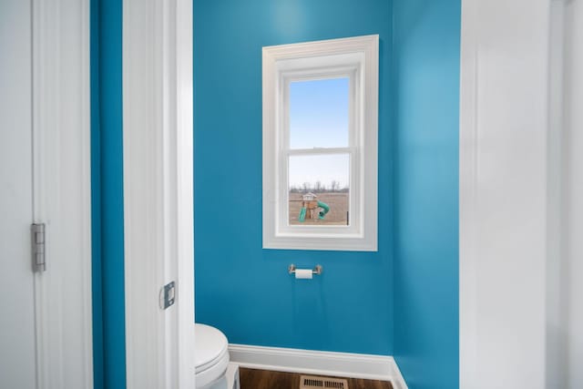 bathroom featuring toilet, baseboards, and wood finished floors