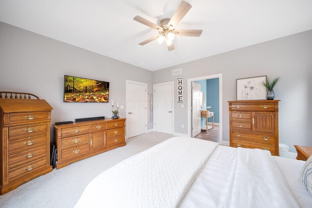 bedroom with a ceiling fan, light colored carpet, and visible vents