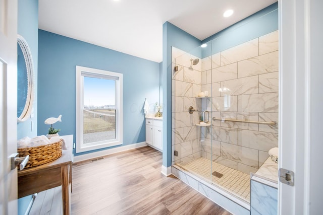 full bathroom with visible vents, a shower stall, baseboards, wood finished floors, and vanity