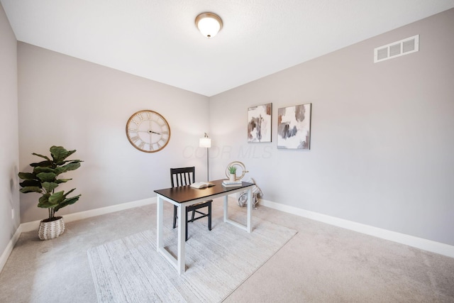 carpeted office space featuring baseboards and visible vents