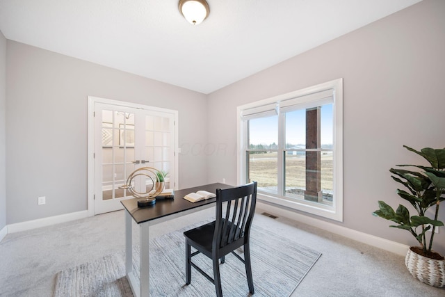 office area featuring visible vents, light colored carpet, baseboards, and french doors