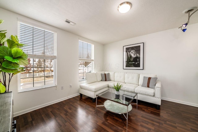 living area with visible vents, baseboards, and wood finished floors