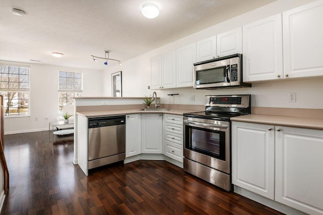 kitchen featuring white cabinetry, light countertops, dark wood-style flooring, and stainless steel appliances