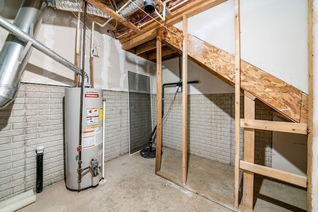 below grade area featuring water heater and brick wall