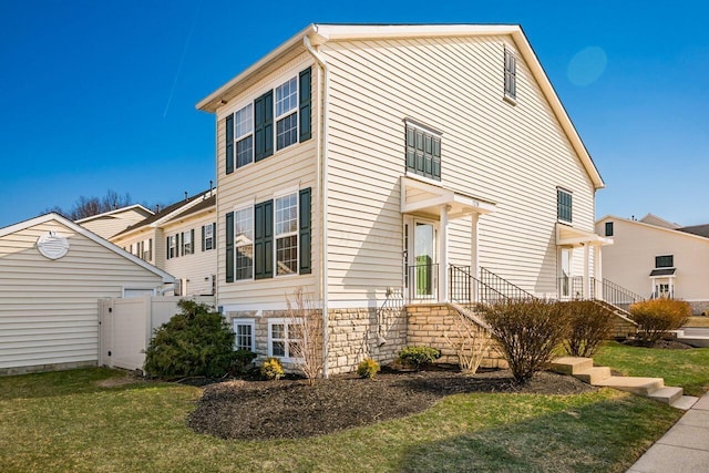 exterior space with stone siding, a yard, and fence