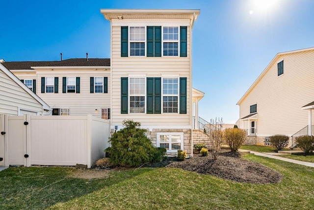 exterior space featuring stairway, a lawn, and fence