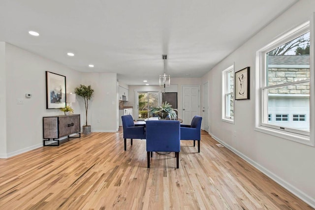 dining space with recessed lighting, light wood-style flooring, and baseboards