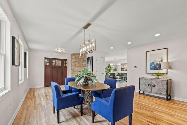 dining room with baseboards, light wood-style flooring, and a notable chandelier