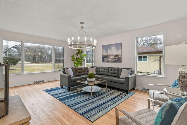 living room featuring wood finished floors, visible vents, and a healthy amount of sunlight