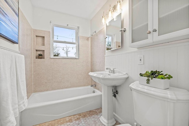 full bathroom with shower / bathtub combination, a wainscoted wall, tile patterned flooring, and toilet