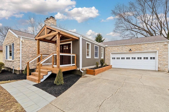 view of front of house featuring roof with shingles, a chimney, a garage, stone siding, and driveway