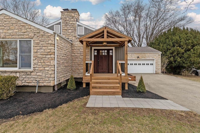 view of front facade featuring driveway, stone siding, a chimney, an attached garage, and board and batten siding