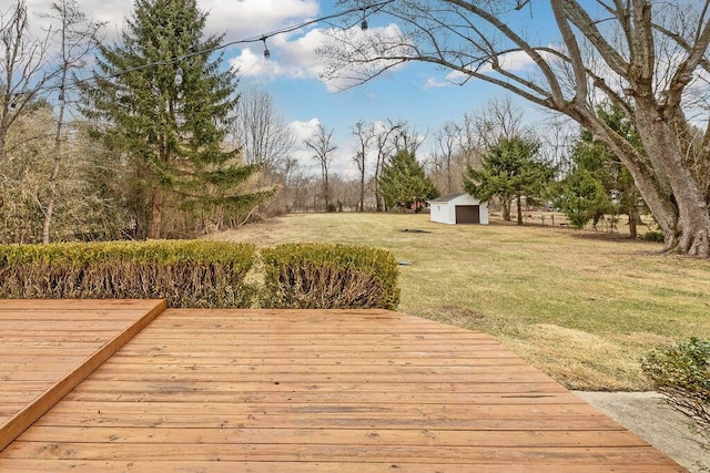 wooden terrace featuring a yard, a storage unit, and an outdoor structure