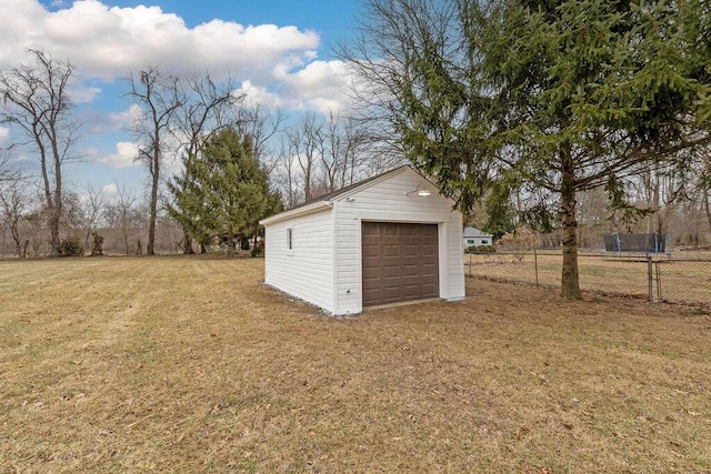 exterior space featuring a garage, driveway, an outdoor structure, and fence