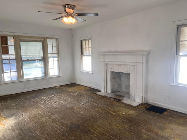 unfurnished living room with a wealth of natural light, a brick fireplace, visible vents, and hardwood / wood-style floors