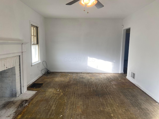 unfurnished living room featuring a brick fireplace, a ceiling fan, visible vents, and hardwood / wood-style flooring