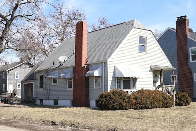 view of home's exterior with a yard, a shingled roof, and a chimney