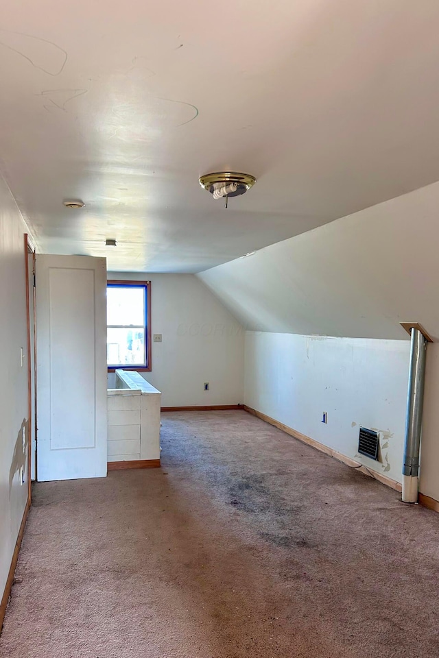 additional living space with vaulted ceiling, carpet flooring, and baseboards