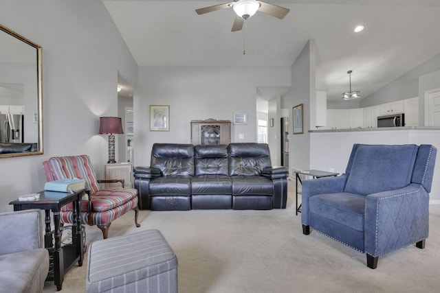 living area with light carpet, ceiling fan, and vaulted ceiling