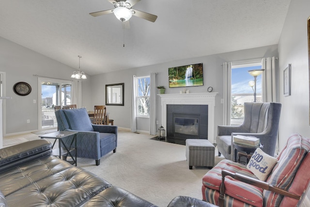 living area with lofted ceiling, light carpet, ceiling fan with notable chandelier, a fireplace, and baseboards