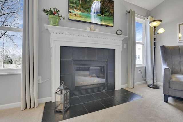 room details featuring carpet, baseboards, and a tile fireplace