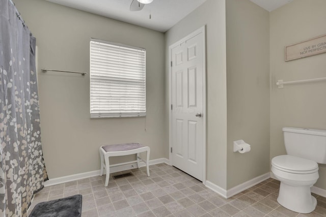 full bath with a shower with shower curtain, baseboards, ceiling fan, and toilet