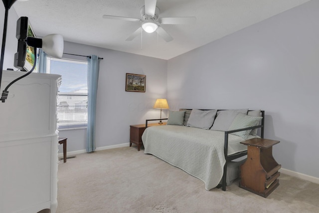 carpeted bedroom featuring ceiling fan, baseboards, and a textured ceiling