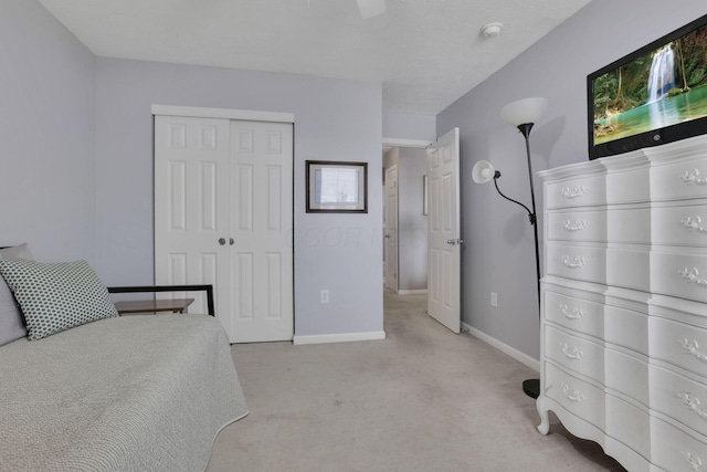 carpeted bedroom with ceiling fan, a closet, and baseboards