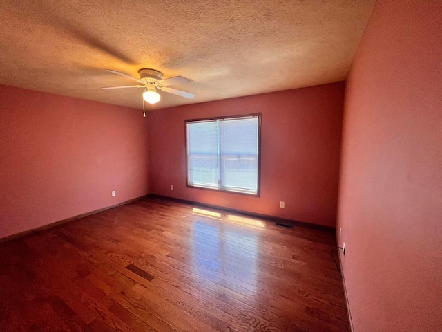 1396 Spring Village Dr, Mansfield, OH 44906 - empty room with wood finished floors, ceiling fan, baseboards, and a textured ceiling