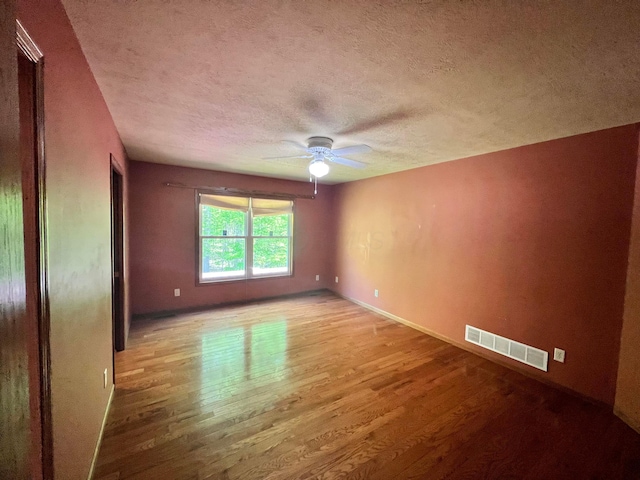 1396 Spring Village Dr, Mansfield, OH 44906 - empty room with wood finished floors, a ceiling fan, a textured ceiling, and baseboards