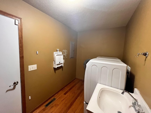 1396 Spring Village Dr, Mansfield, OH 44906 - bathroom with a sink, wood finished floors, washer and dryer, electric panel, and a textured ceiling