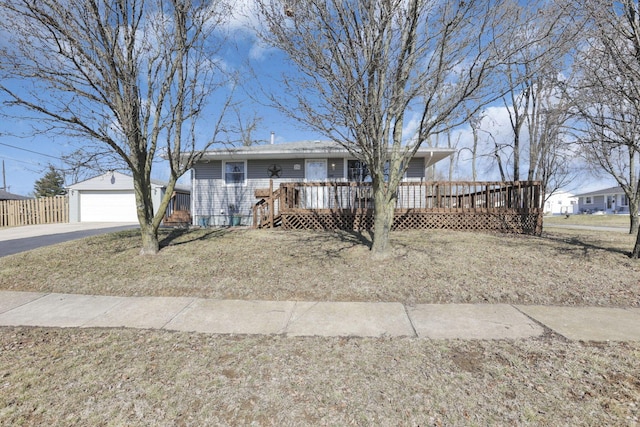 single story home with a detached garage, a deck, and an outbuilding