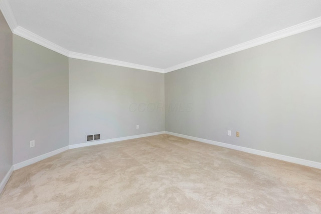 empty room with light carpet, visible vents, crown molding, and baseboards