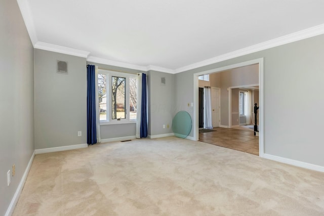 spare room featuring visible vents, carpet floors, baseboards, and ornamental molding