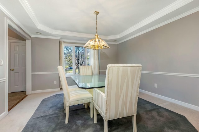 carpeted dining space with crown molding and baseboards