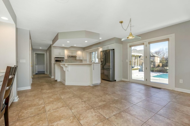 kitchen featuring visible vents, a kitchen breakfast bar, white cabinetry, stainless steel appliances, and light countertops