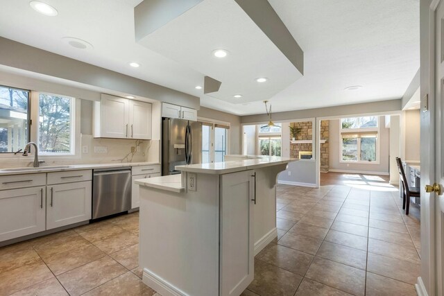 kitchen with a sink, plenty of natural light, appliances with stainless steel finishes, and light countertops