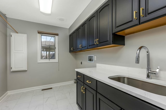 washroom with baseboards, hookup for a washing machine, cabinet space, marble finish floor, and a sink