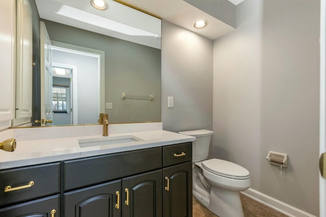 bathroom featuring tile patterned floors, toilet, recessed lighting, baseboards, and vanity